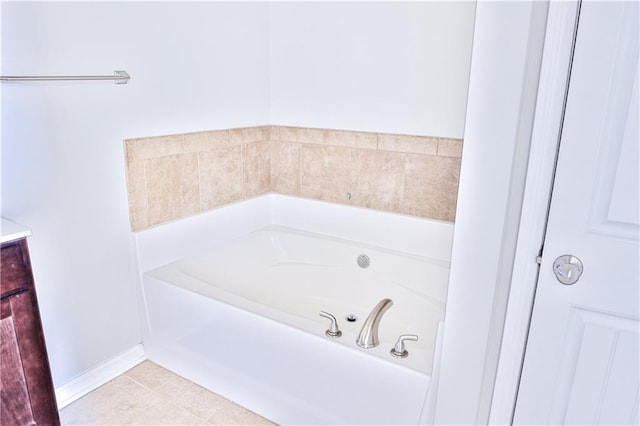 bathroom with tile patterned flooring, a bath, and vanity