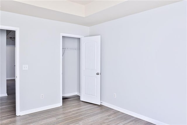 unfurnished bedroom with light hardwood / wood-style floors and a closet