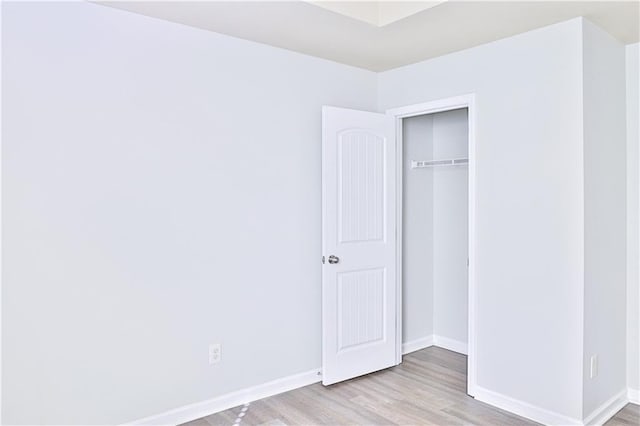 unfurnished bedroom featuring light wood-type flooring and a closet