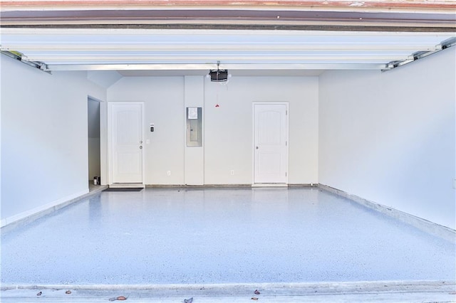 garage with a garage door opener and electric panel