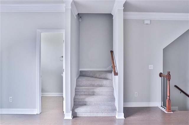 stairway featuring ornamental molding and hardwood / wood-style floors