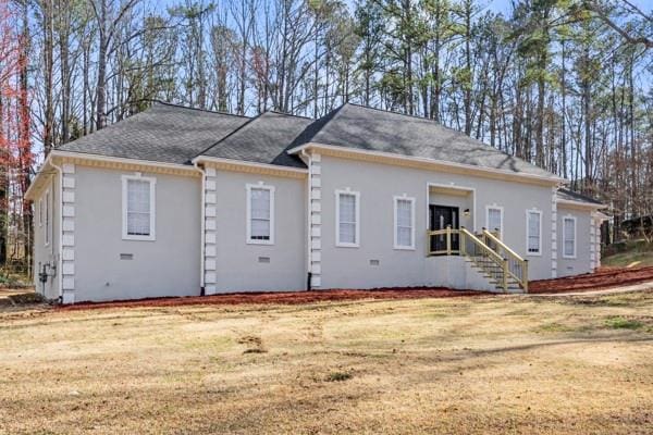 back of house featuring a yard and stucco siding