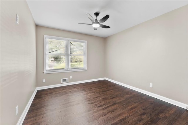 spare room featuring visible vents, baseboards, dark wood-style floors, and a ceiling fan