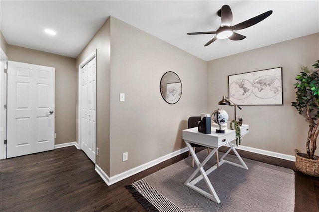 office space with baseboards, ceiling fan, and dark wood-style flooring