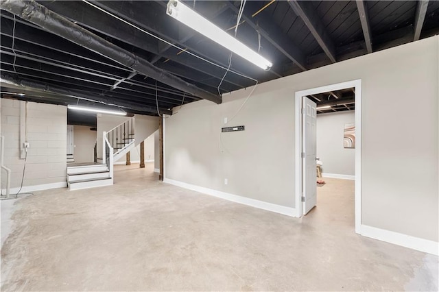 finished below grade area featuring baseboards and stairs