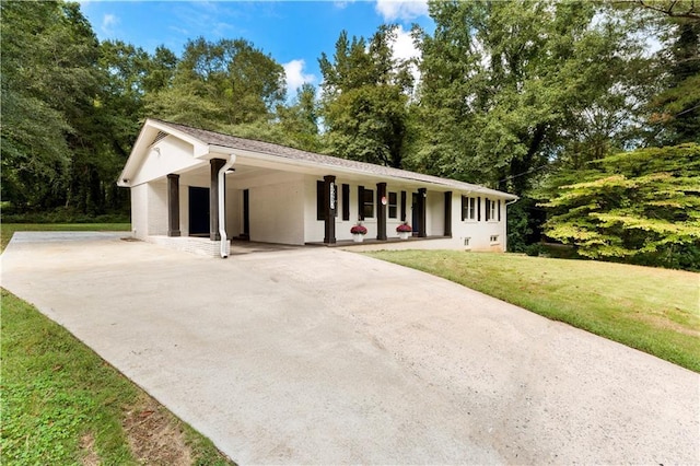 single story home featuring an attached carport, a front lawn, and driveway