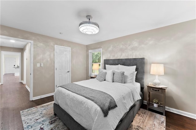 bedroom featuring baseboards, attic access, and wood finished floors