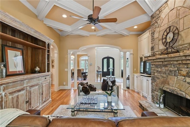 living room with beamed ceiling, coffered ceiling, and light hardwood / wood-style floors