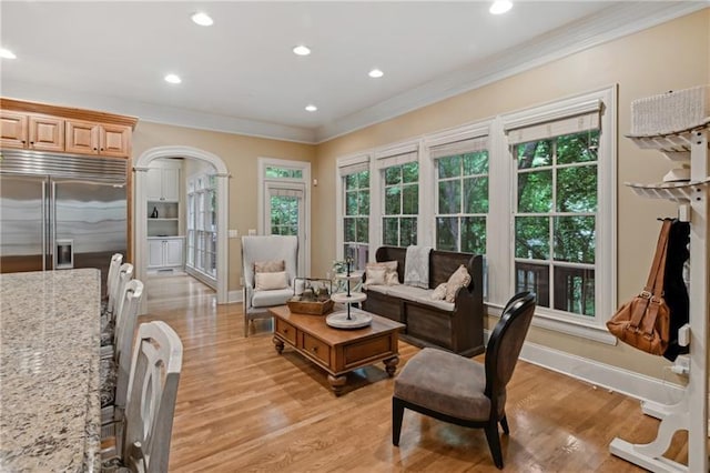 living room with ornamental molding and light hardwood / wood-style flooring