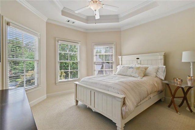 bedroom featuring ceiling fan, light colored carpet, ornamental molding, and a raised ceiling