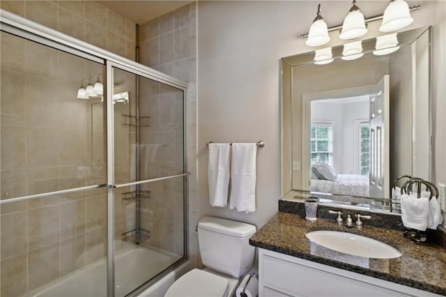 full bathroom with toilet, vanity, and bath / shower combo with glass door