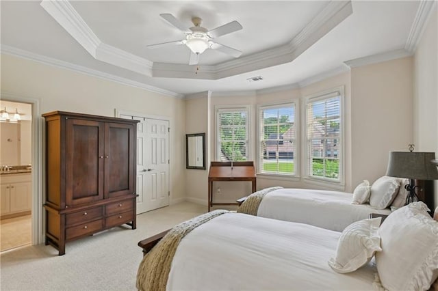 carpeted bedroom featuring ceiling fan, crown molding, connected bathroom, and a raised ceiling