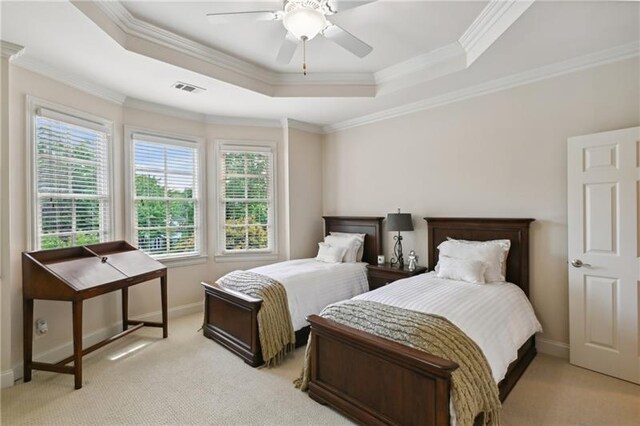 bedroom featuring ceiling fan, ornamental molding, light colored carpet, and a raised ceiling