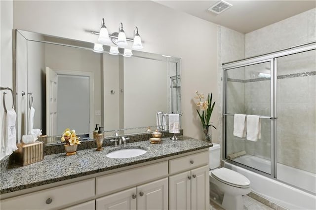 full bathroom featuring toilet, tile patterned floors, vanity, and shower / bath combination with glass door