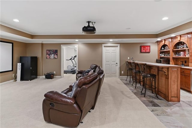 cinema room featuring crown molding, light colored carpet, and bar area