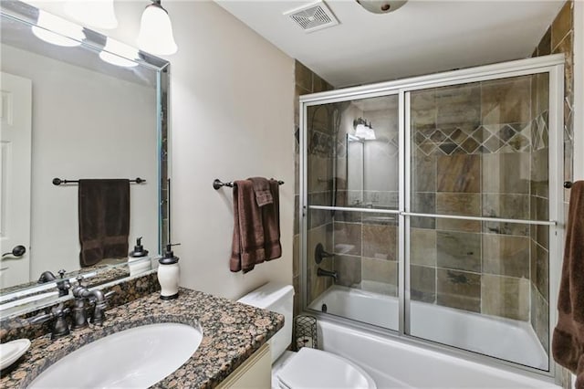 full bathroom featuring toilet, vanity, and enclosed tub / shower combo