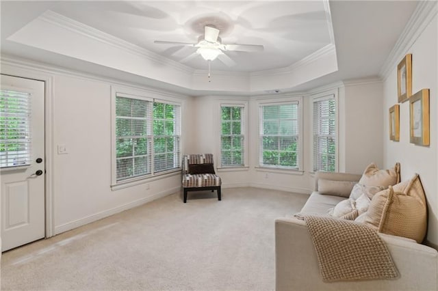 sitting room featuring ceiling fan, light colored carpet, crown molding, and a tray ceiling