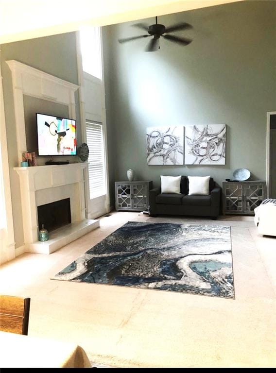 6265 Lake Windsor Pkwy, Buford, GA 30518 - carpeted living area with a fireplace with raised hearth, a high ceiling, and a ceiling fan