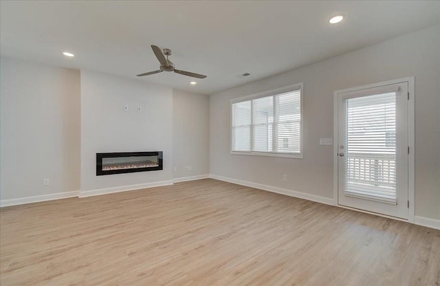 3338 Cranston Ln, Kennesaw, GA 30144 - unfurnished living room featuring light wood-style floors, a ceiling fan, a glass covered fireplace, baseboards, and recessed lighting