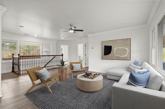 living area with crown molding, a wealth of natural light, and wood finished floors