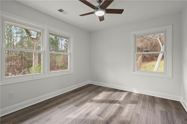spare room featuring a ceiling fan, baseboards, visible vents, and wood finished floors