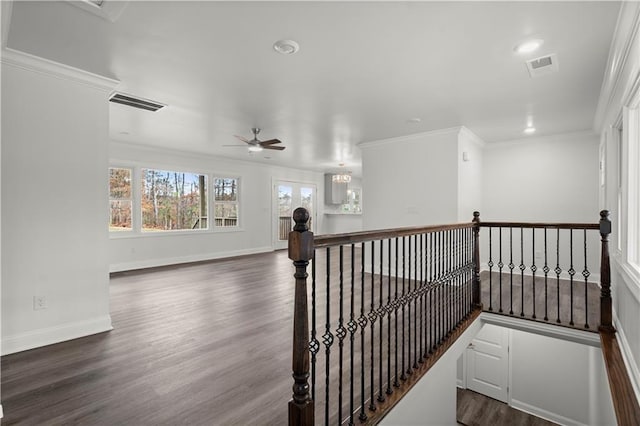 corridor with dark wood-type flooring, baseboards, visible vents, and an upstairs landing