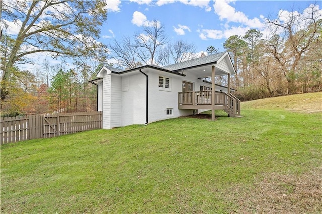 view of side of property featuring a lawn, fence, and a deck