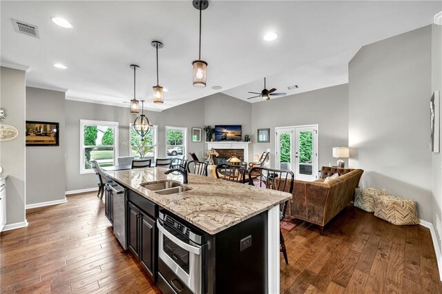 kitchen with sink, plenty of natural light, decorative light fixtures, vaulted ceiling, and a kitchen bar