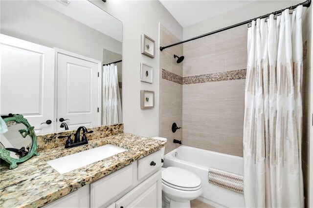 full bathroom featuring shower / bath combo, toilet, and vanity