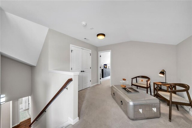 sitting room with light carpet and vaulted ceiling