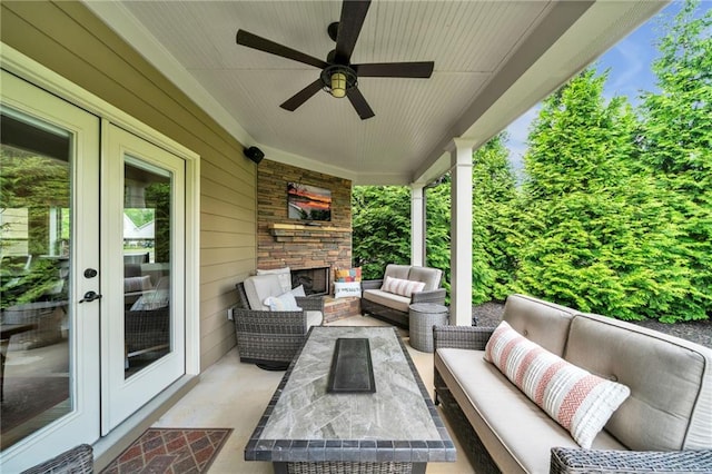 view of patio / terrace with an outdoor living space with a fireplace, french doors, and ceiling fan