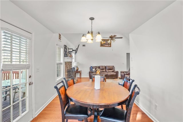 dining room featuring light wood-type flooring, baseboards, and ceiling fan with notable chandelier