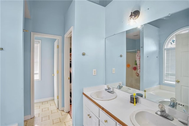 bathroom featuring double vanity, a garden tub, a sink, and tile patterned floors