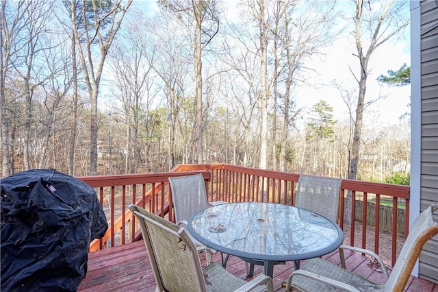 wooden terrace featuring area for grilling and outdoor dining space