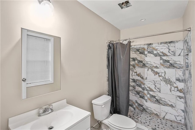 bathroom with a stall shower, vanity, and toilet