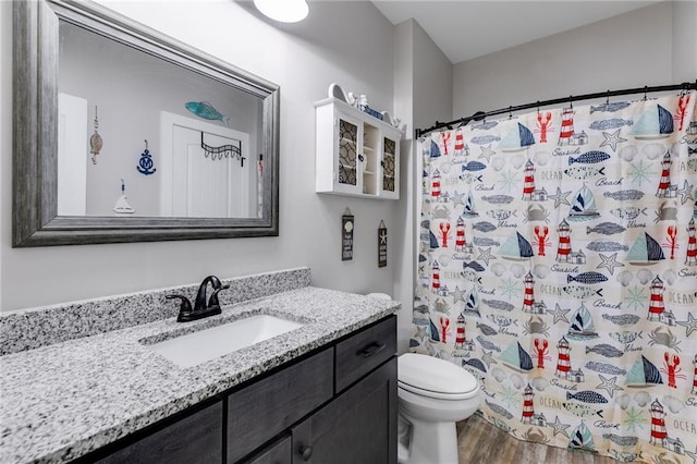 bathroom with vanity, wood-type flooring, curtained shower, and toilet