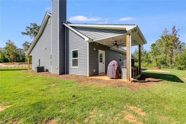 rear view of property with ceiling fan, a yard, central AC unit, and a patio area