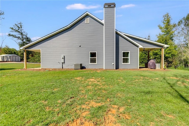 back of house with cooling unit, a yard, and a shed