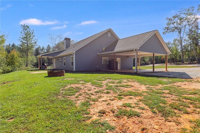 rear view of house with a yard and a carport