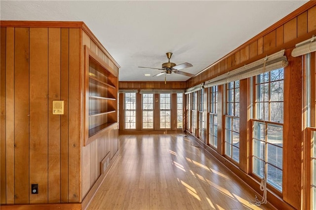 unfurnished sunroom with ceiling fan and a wealth of natural light