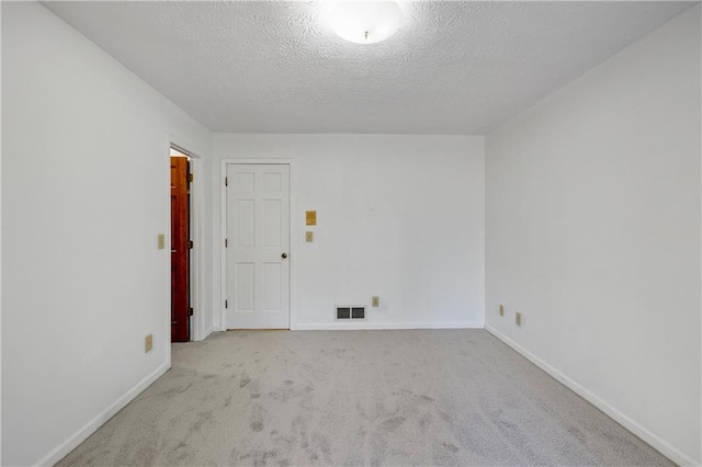 carpeted spare room featuring a textured ceiling