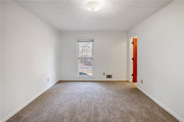 empty room with carpet and a textured ceiling