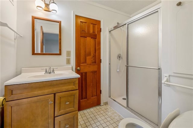 bathroom with tile patterned floors, toilet, a shower with shower door, crown molding, and vanity