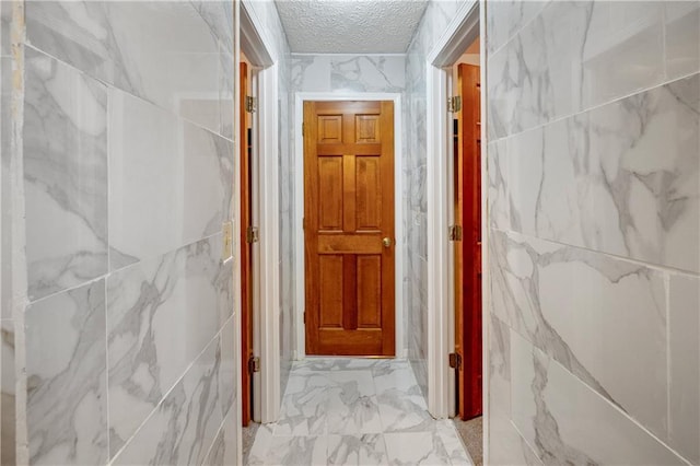 hall featuring a textured ceiling