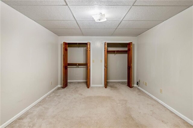 unfurnished bedroom with two closets and light carpet