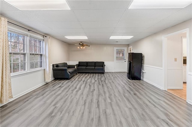 living room with a drop ceiling and light hardwood / wood-style floors