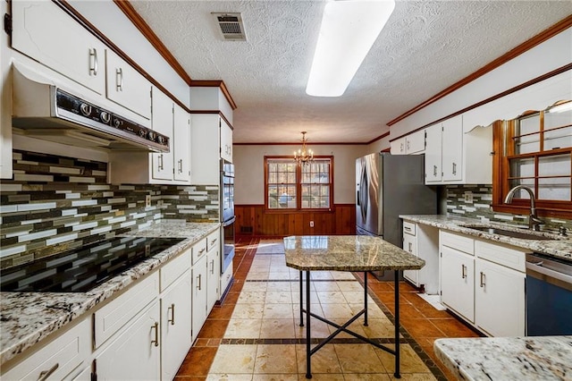 kitchen with white cabinetry, sink, a chandelier, light stone counters, and stainless steel appliances