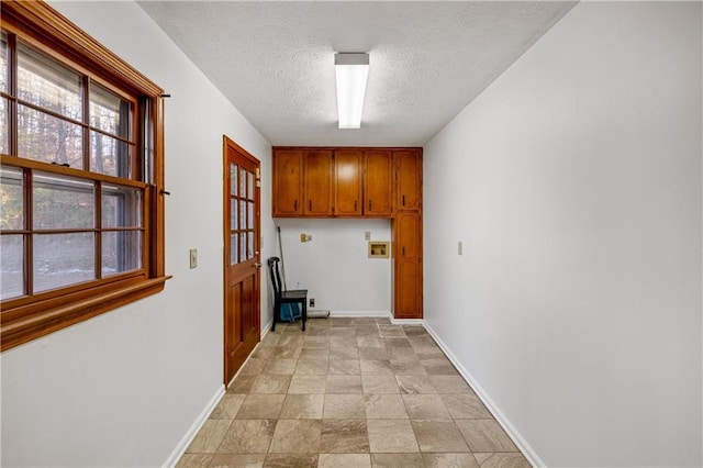 clothes washing area featuring cabinets, washer hookup, and a textured ceiling