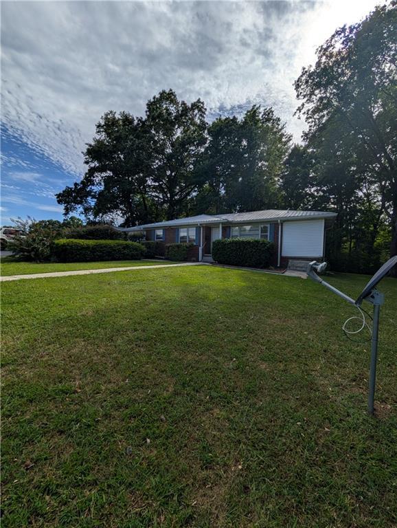 ranch-style home with a garage and a front lawn