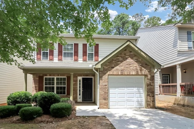 view of front of property with brick siding, covered porch, driveway, and a garage